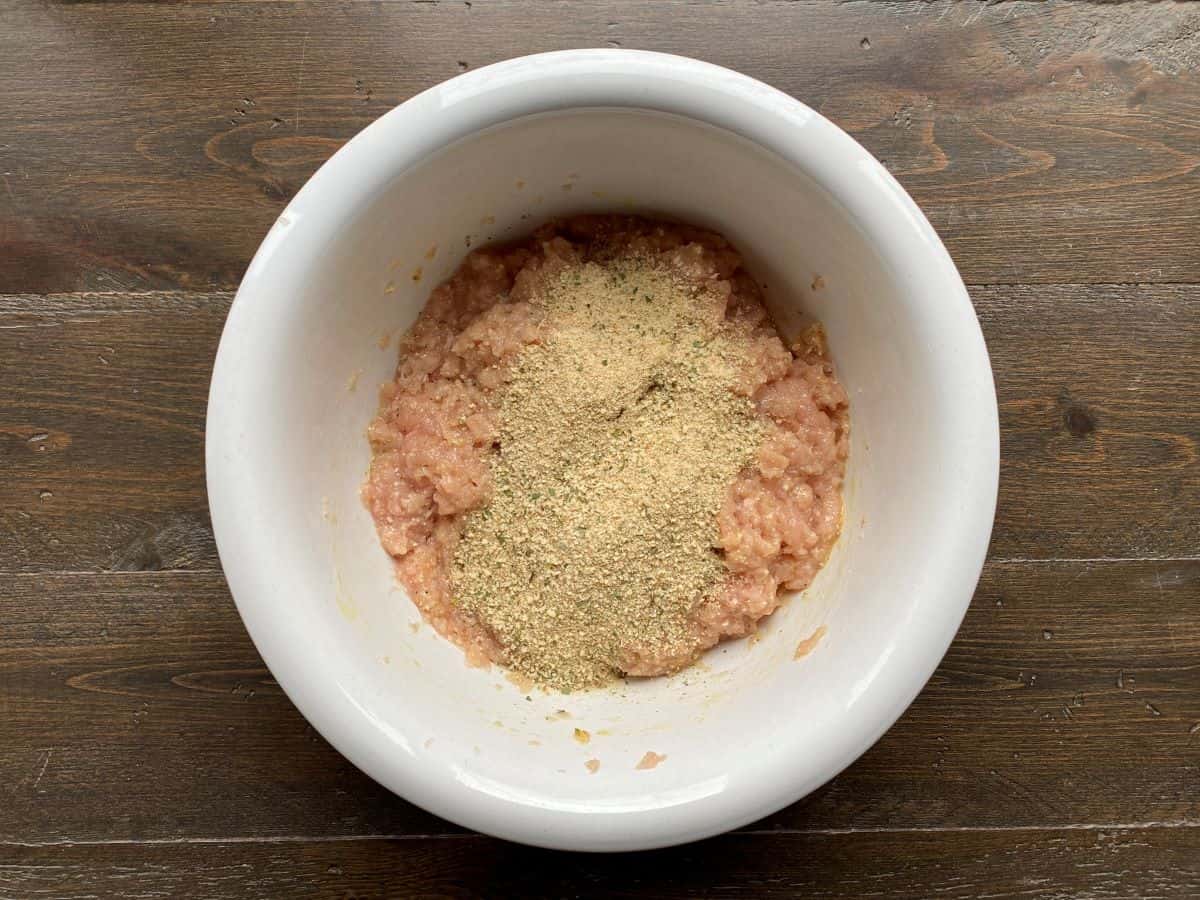 Breadcrumbs on top of the chicken mixture in a large bowl.